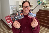 Julia Wittreck mit zwei Sternschnuppen in den Händen, einer Papiersternschnuppe und einer aufladbaren Karte.