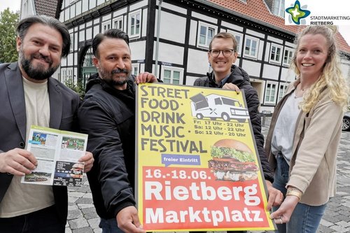 Die Organisatoren des Streetfood-Festivals mit dem Plakat für das Event.