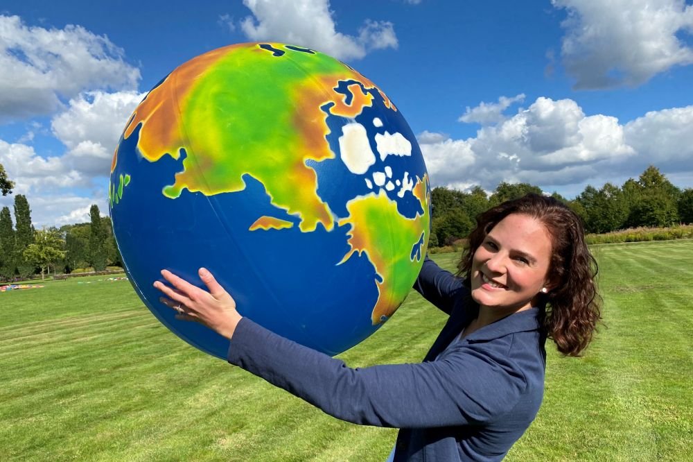 Klimaschutzmanagerin Svenja Schröder mit einer großen Weltkugel in der Hand.