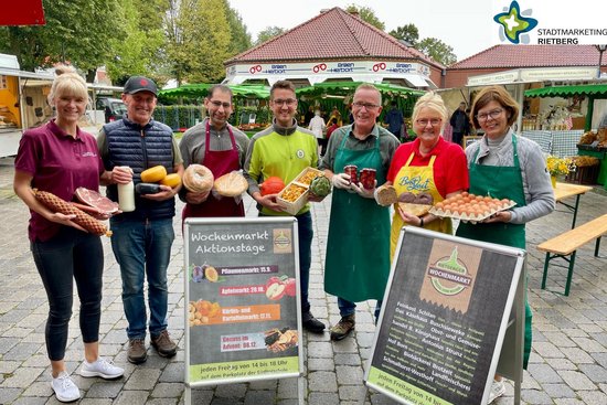 Rietberger Markthändler mit frischen Produkten vor der Wochenmarkt-Kulisse.