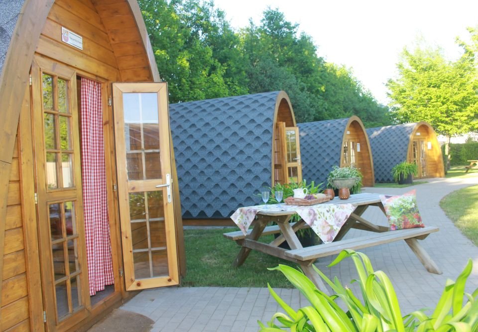 Die Camping Pods im Gartenschaupark mit einem dekorativ gedeckten Tisch vor der Tür.