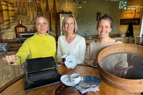 Zwei Mitarbeiterinnen der Touristikinformation und Christina Hagenkort mit Utensilien zum Kaffeerösten.