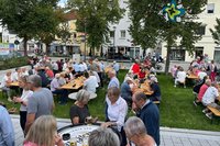 Baustellenfest im August 2025: Menschen sitzen auf dem neuen Platz am Nordtor an Bierzelttischen, im Hintergrund Musiker Patrick Lück.
