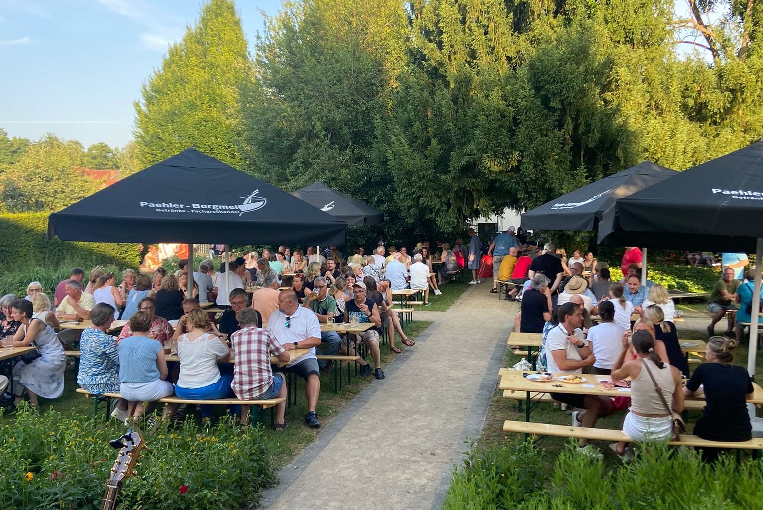 Blick in den Sommerbiergarten im Drostengarten. Viele Besucher sitzen an Bierzeltgarnituren und lassen es sich schmecken.