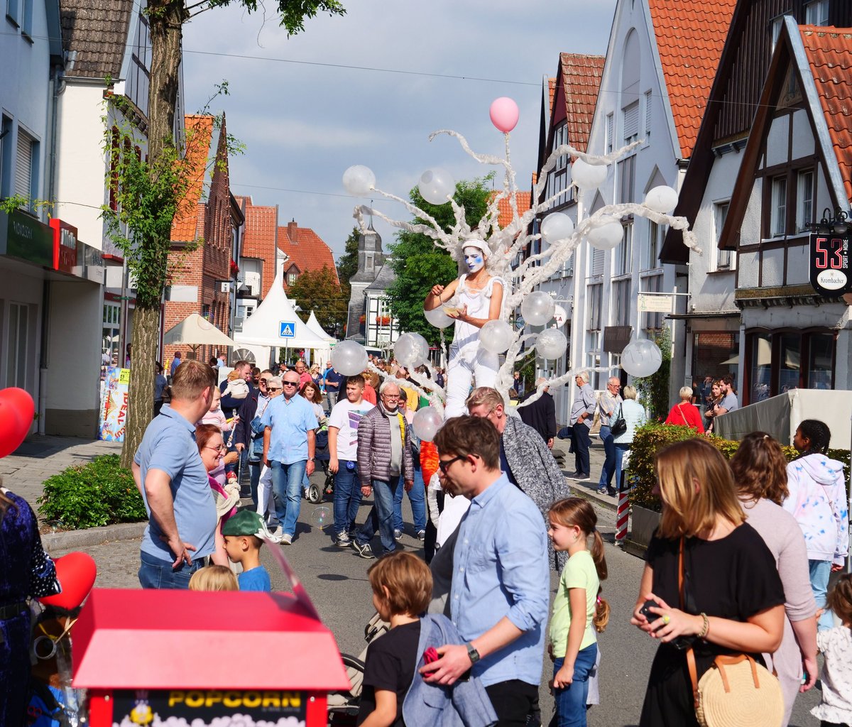 Die Rathausstraße an einem verkaufsoffenen Sonntag mit vielen Menschen und einem Stelzenläufer, der alles überragt.